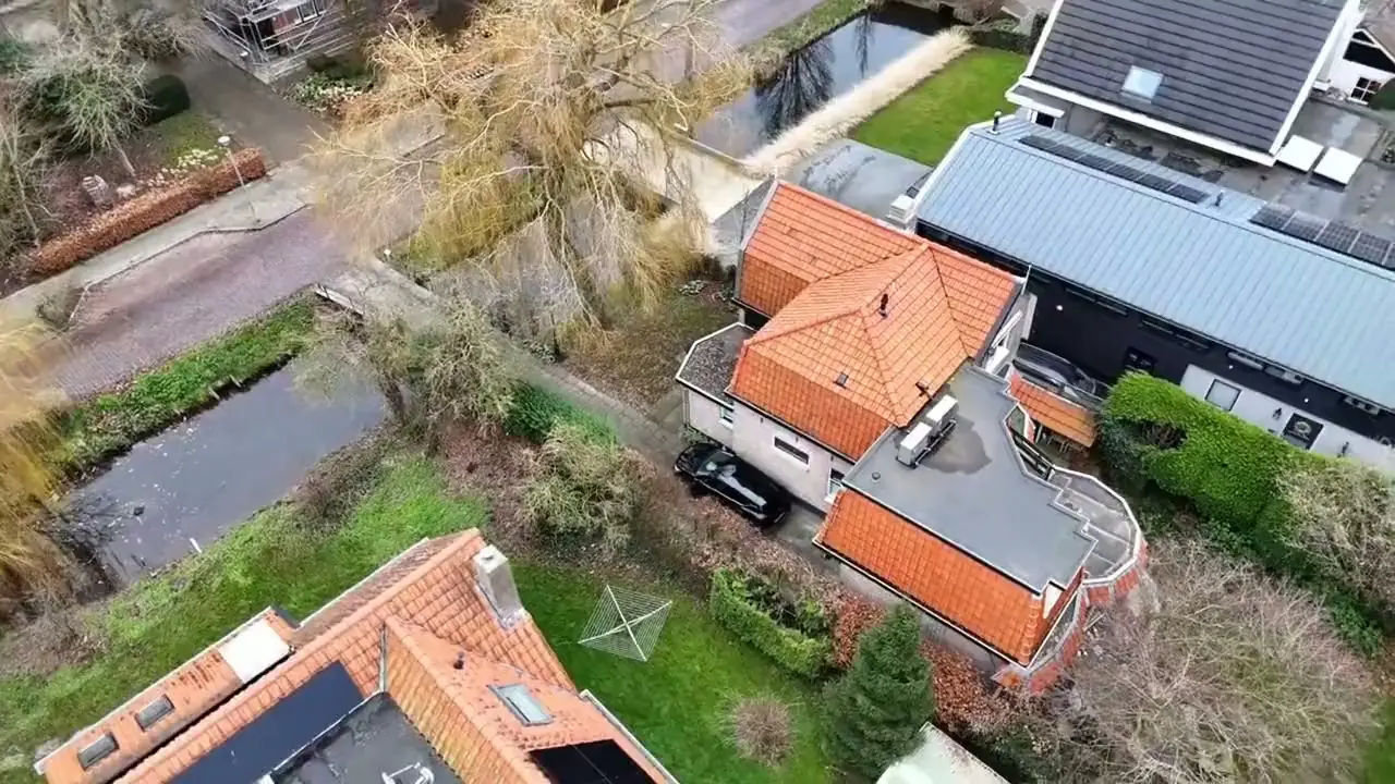 Dronebeeld van daken aan een vaart, zoals het op de site van NH Dakwerken staat